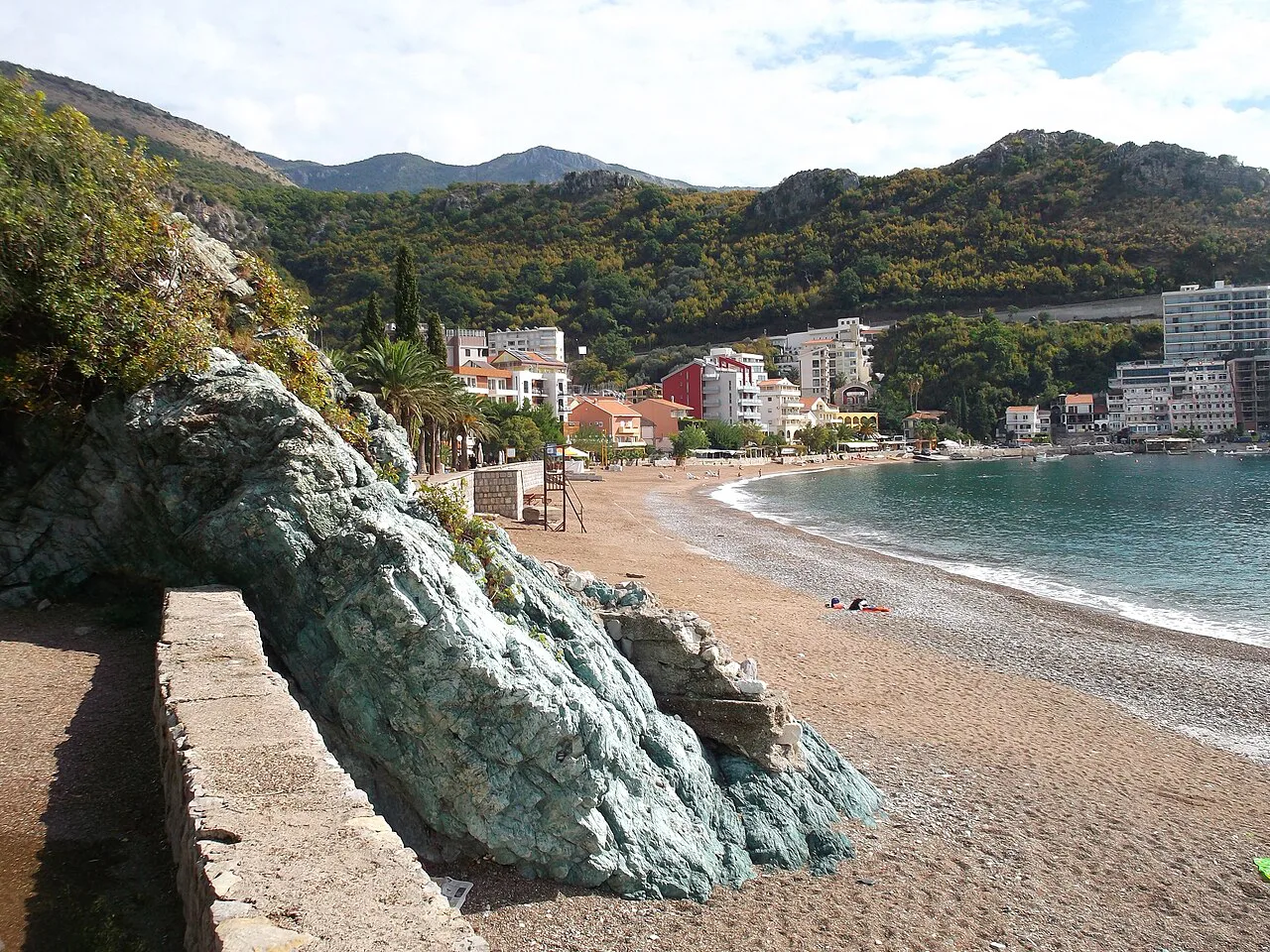 The beach at Bečići beside the rocky shore.