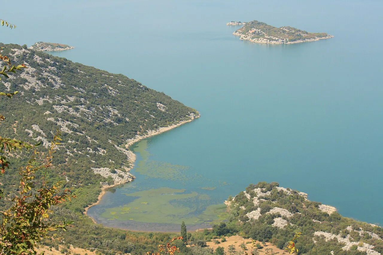 Lake Skadar National Park, with green hills running down to the lake shore.