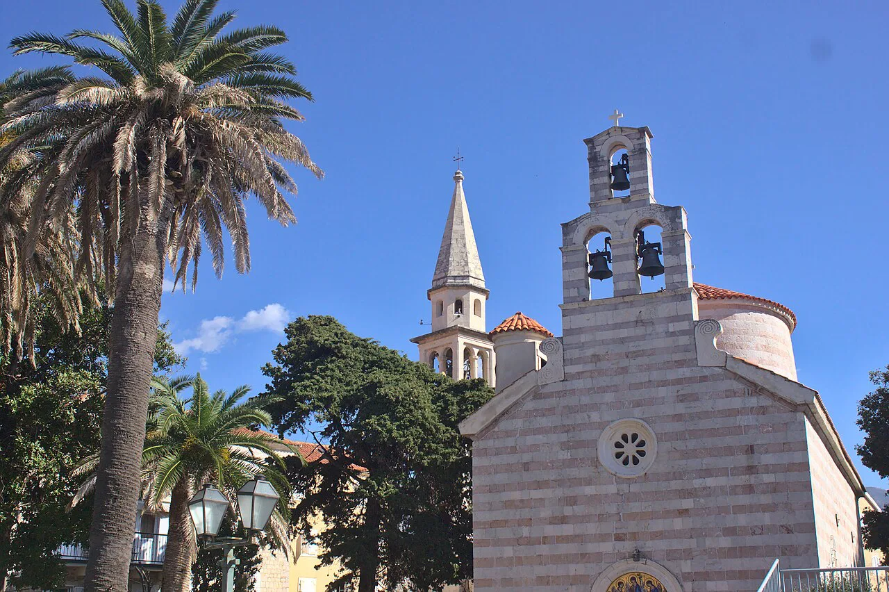 The bell tower and striped facade of the Holy Trinity Church in Budva.