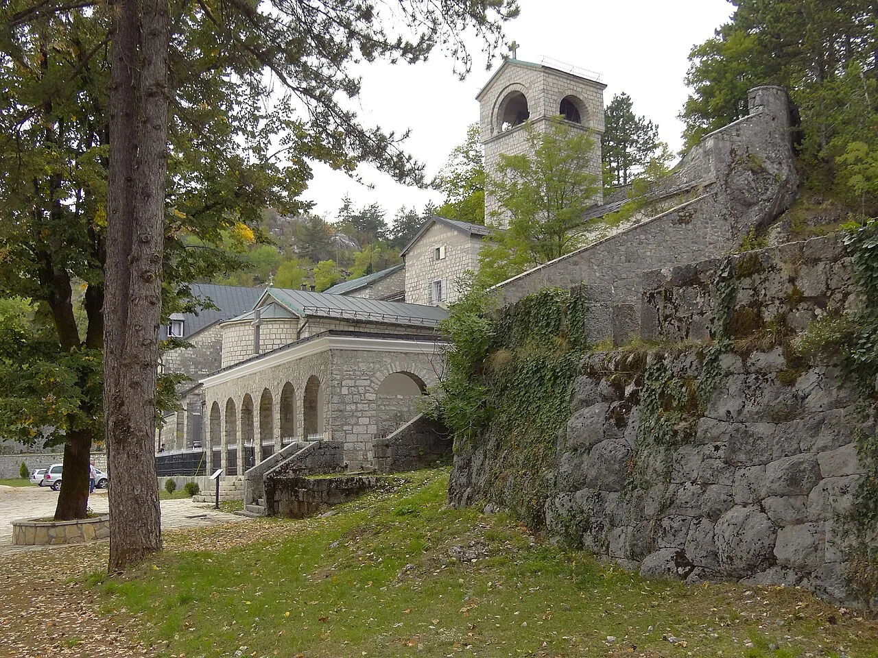 The facade of Cetinje Monastery among trees.