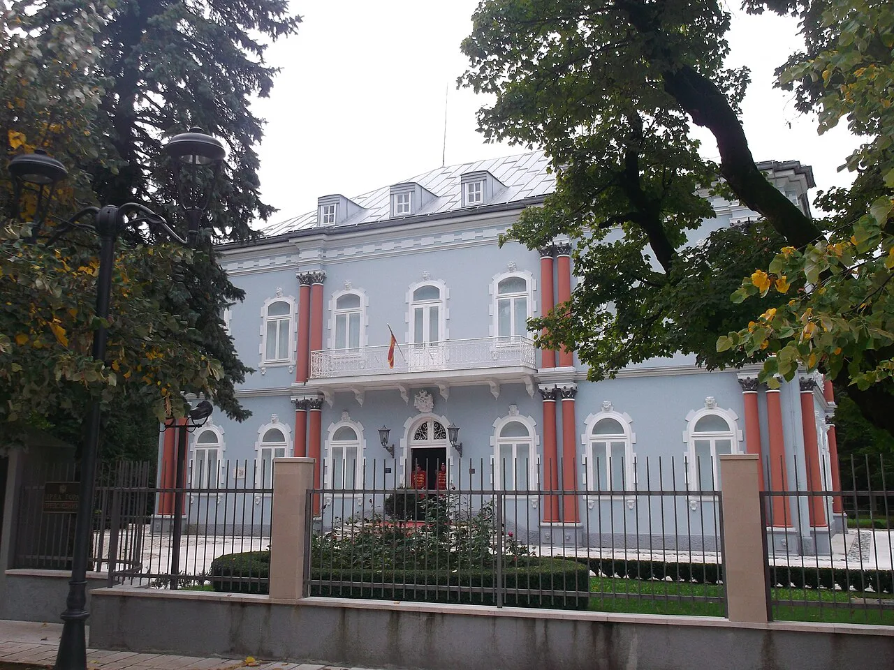 A historic building in Cetinje behind its garden railings.