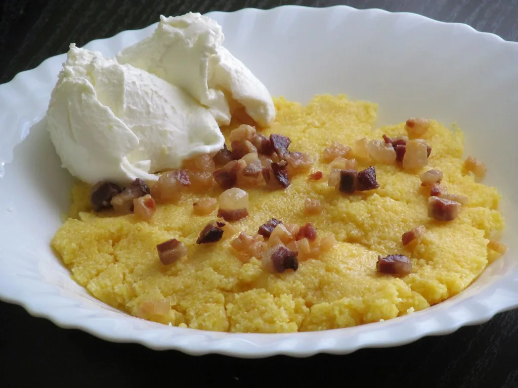 A plate of cicvara topped with cream.