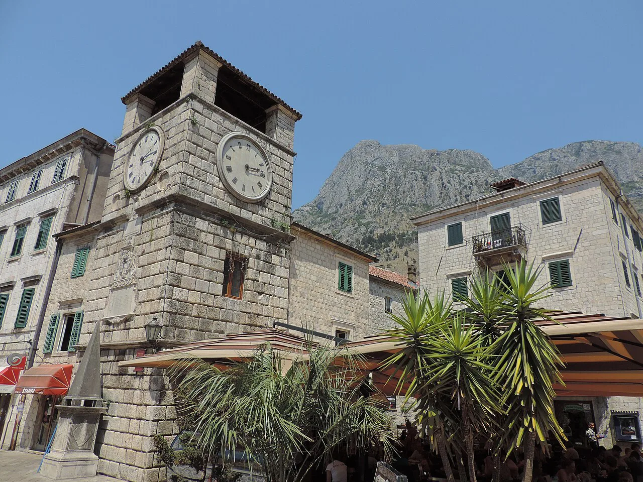 Kotor's Clock Tower on the main square, with mountains behind.