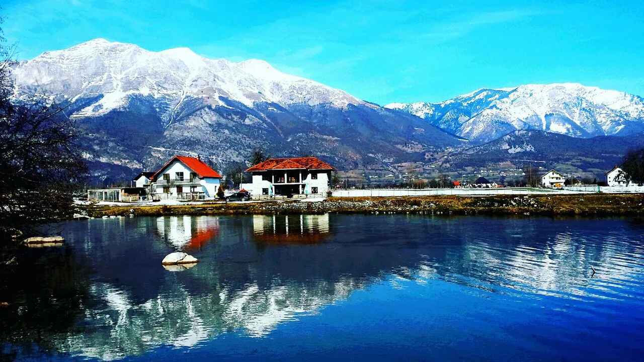 Snow-capped peaks reflected in a pond at Krojet, Gusinje.