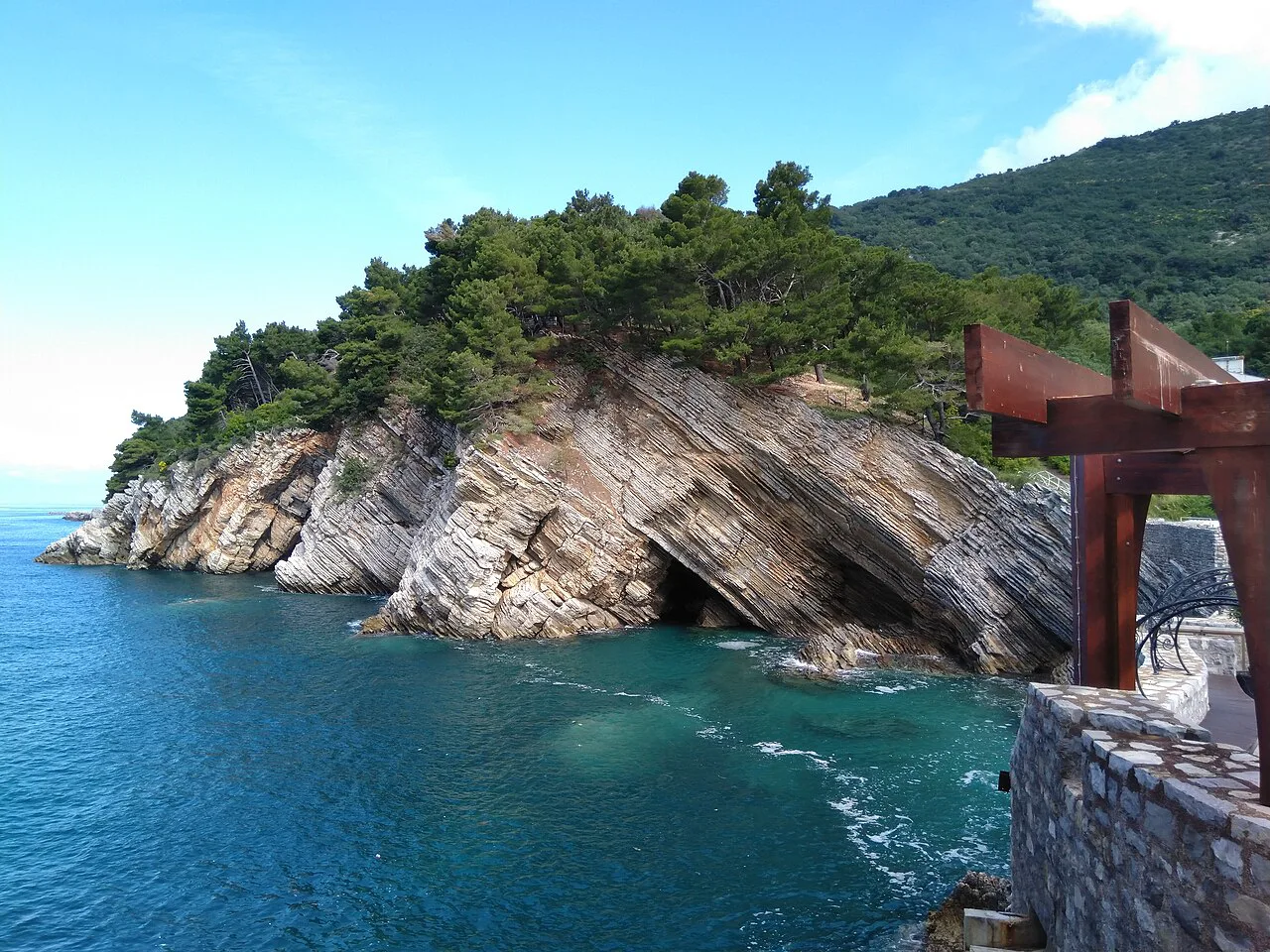 Layered rocks and a turquoise cove along Petrovac's shoreline.