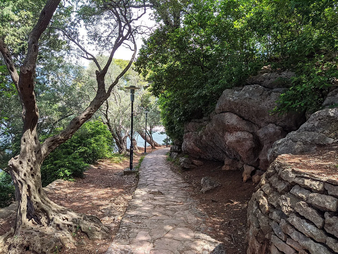A shaded coastal path through Milocer Park.