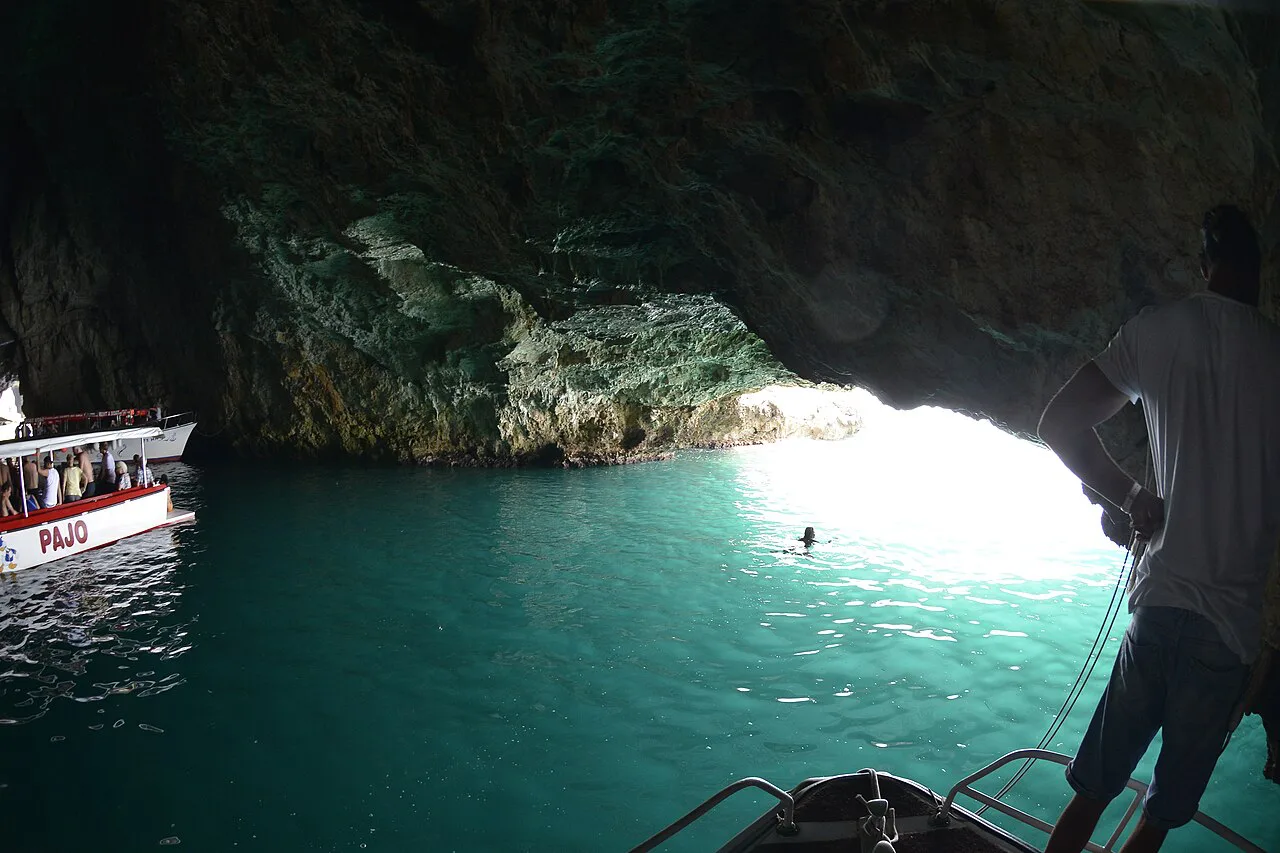 Boats and a swimmer inside the Blue Cave on the Luštica peninsula.