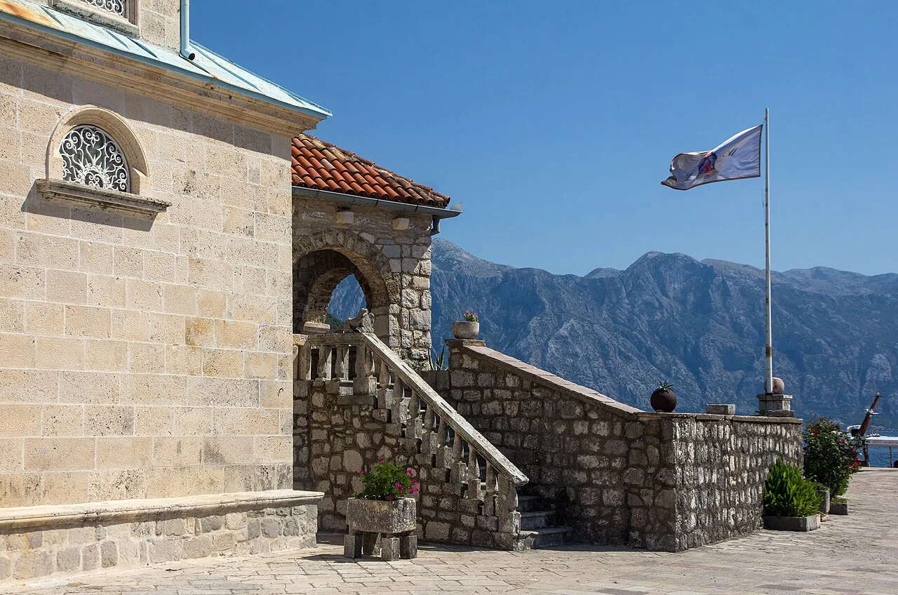 The church on Our Lady of the Rocks, with the bay's mountains behind.