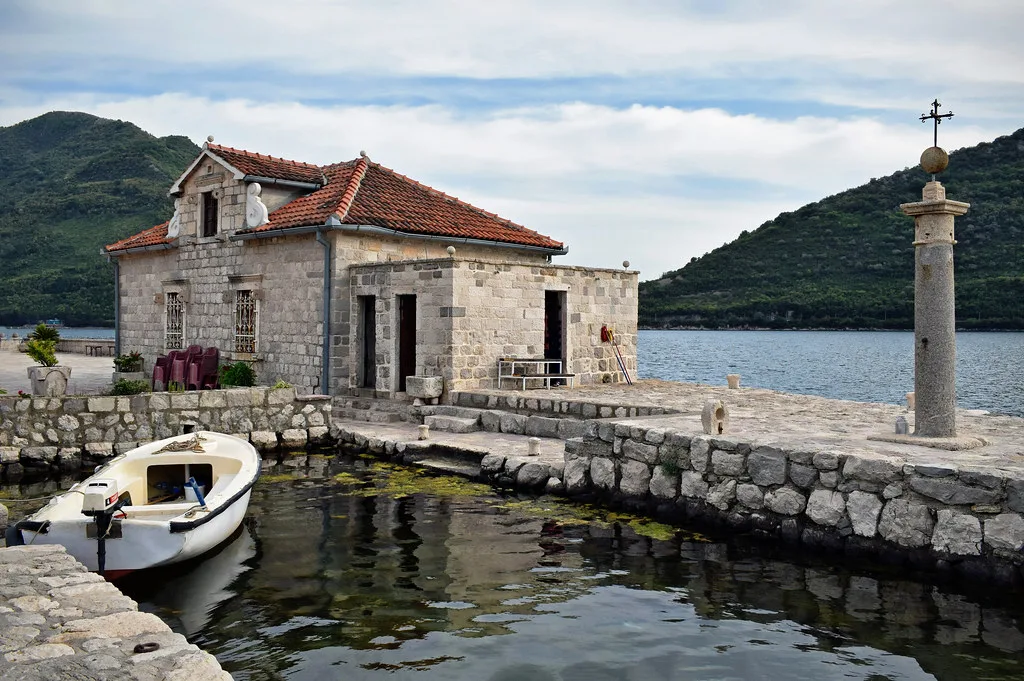 A stone building and jetty on the island of Our Lady of the Rocks, off Perast.