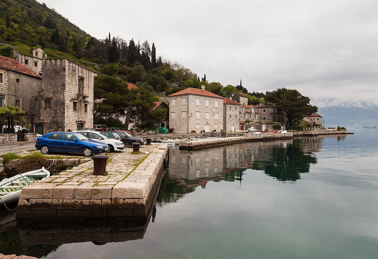 Stone piers and waterfront buildings on the promenade in Perast.