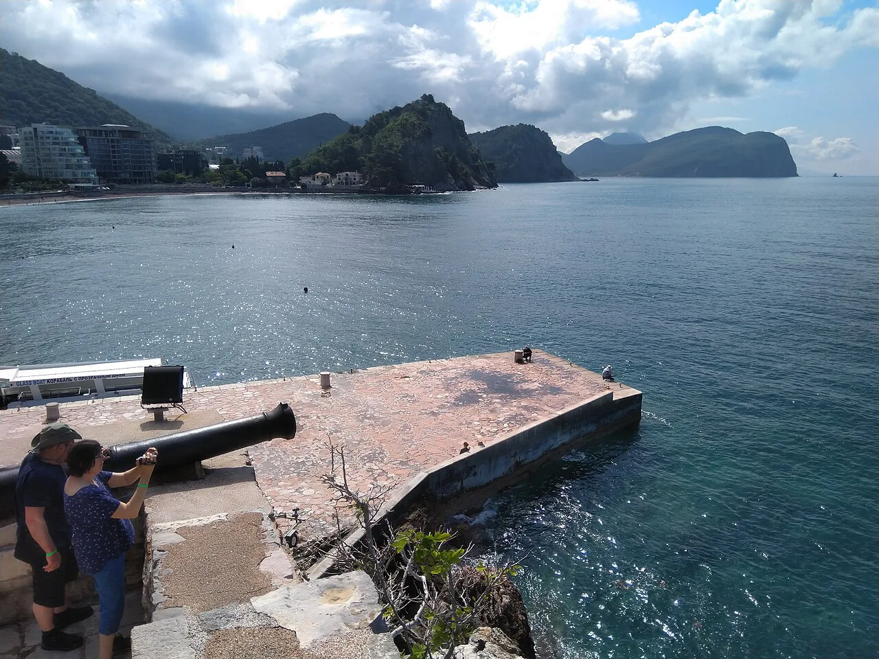 A harbour pier in Petrovac looking out along the rocky coast.