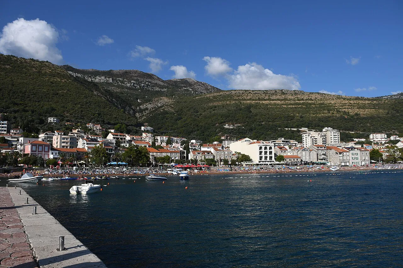 Petrovac's seafront and town beneath wooded hills.