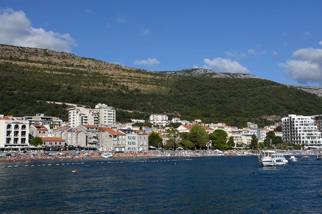 Petrovac's seafront below green hills.