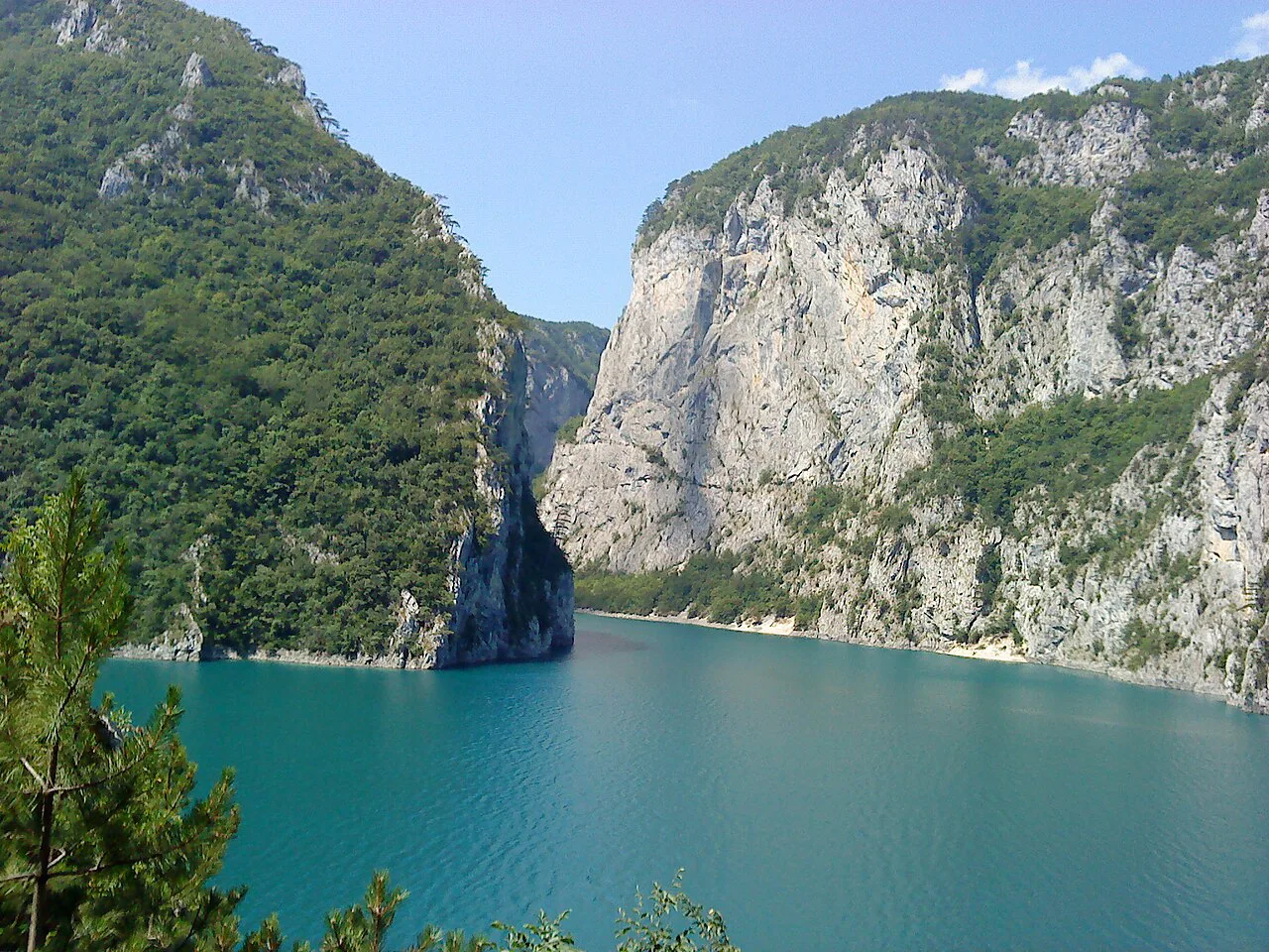 Sheer limestone cliffs above the turquoise water of the Piva Reservoir.