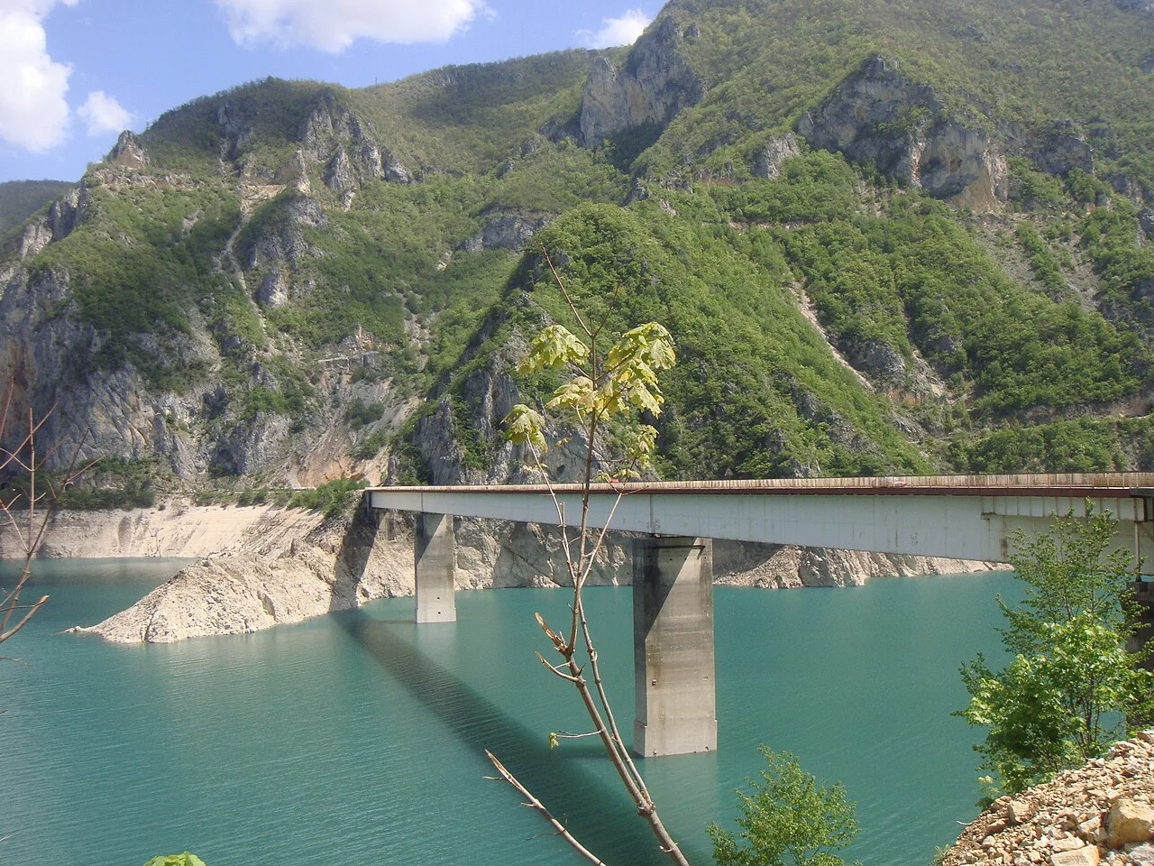 A bridge over the turquoise waters of Piva Lake near Plužine.