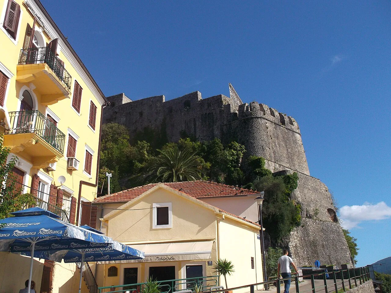 Fortress walls rising above houses in Herceg Novi.