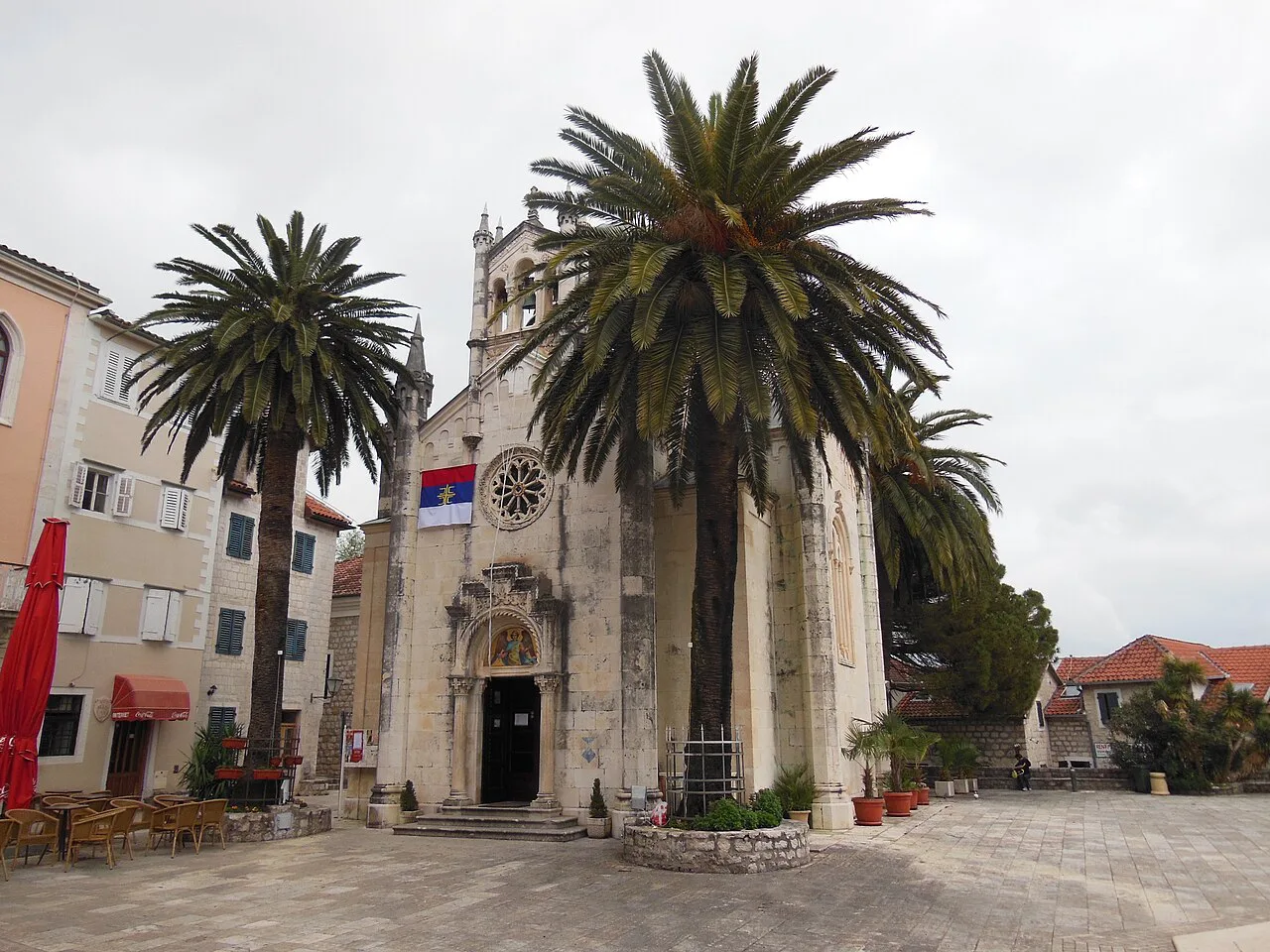 The Church of St Michael the Archangel framed by palm trees in Herceg Novi Old Town.