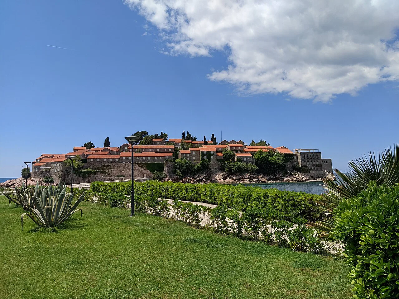 Sveti Stefan island viewed across the lawns of the shoreline park.